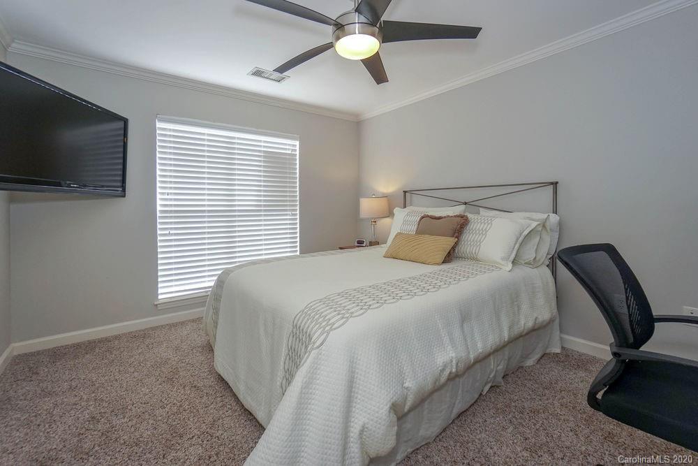 1114 Torrence Circle, Unit 1114 Davidson, NC 28036 - Photo 21 of 29 a bedroom with a bed tv and a window