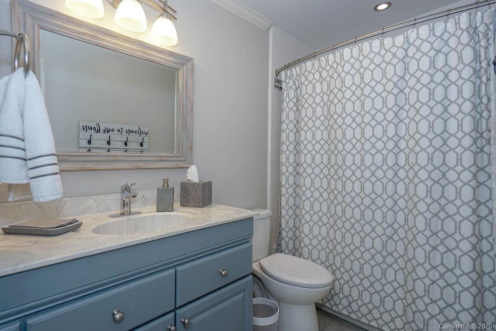 1114 Torrence Circle, Unit 1114 Davidson, NC 28036 - Photo 22 of 29 a bathroom with a granite countertop toilet and a sink