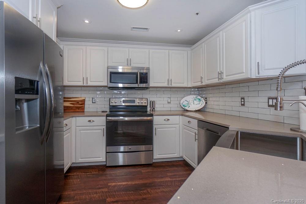 1114 Torrence Circle, Unit 1114 Davidson, NC 28036 - Photo 5 of 29 a kitchen with stainless steel appliances granite countertop a refrigerator a stove a sink and a microwave