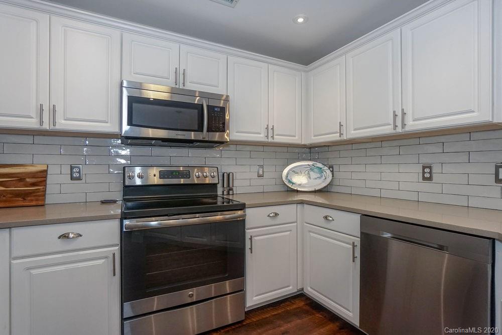 1114 Torrence Circle, Unit 1114 Davidson, NC 28036 - Photo 9 of 29 a kitchen with granite countertop white cabinets and stainless steel appliances