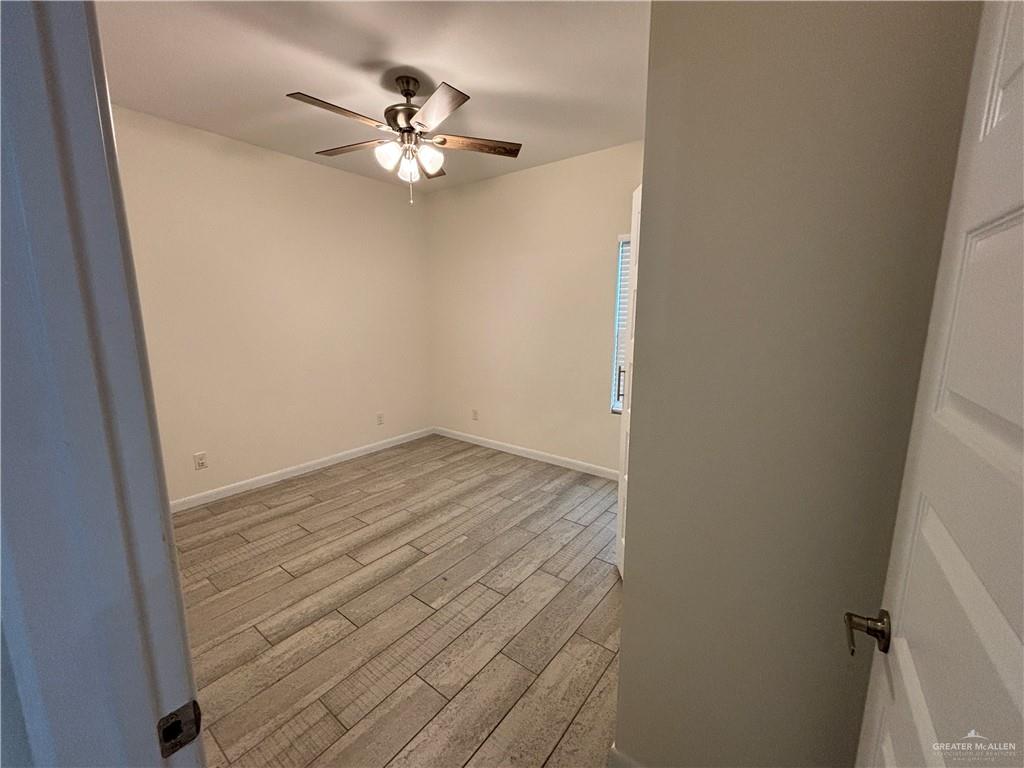 212 Lauryn Drive, Unit 3 San Juan, TX 78589 - Photo 20 of 27 a view of a room with wooden floor and a ceiling fan