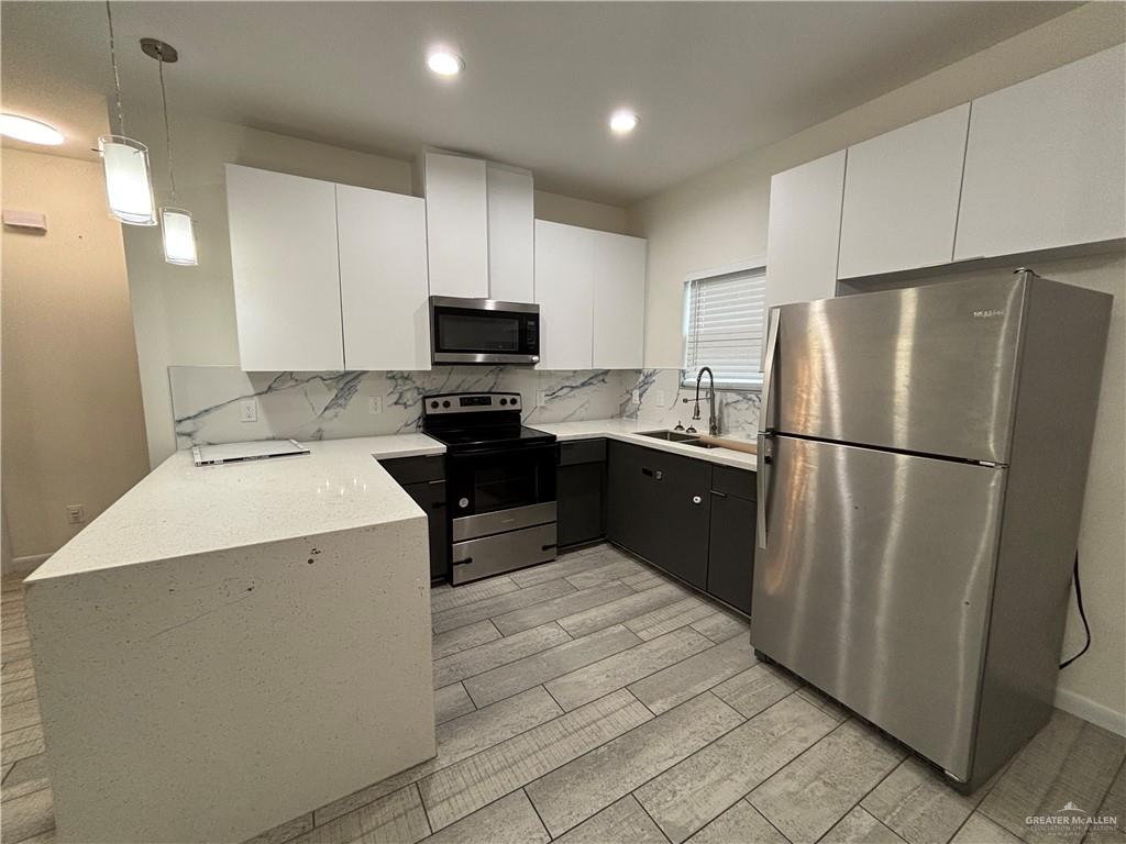 212 Lauryn Drive, Unit 3 San Juan, TX 78589 - Photo 3 of 27 a kitchen with a sink a refrigerator and a stove top oven
