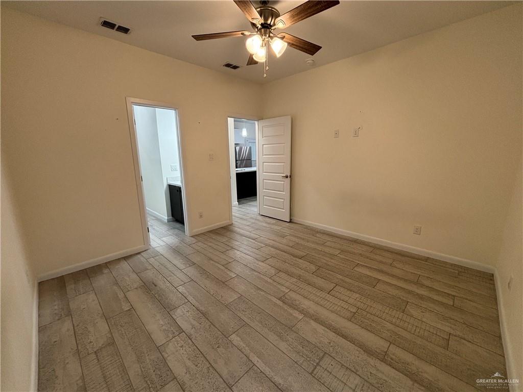 212 Lauryn Drive, Unit 3 San Juan, TX 78589 - Photo 7 of 27 wooden floor in an empty room with a window