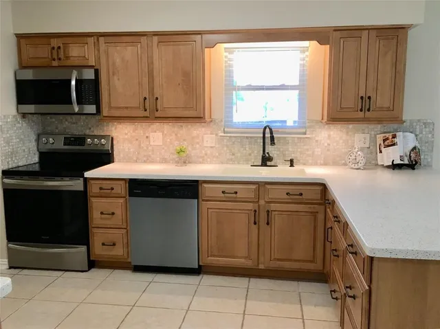 a kitchen with stainless steel appliances granite countertop a sink and a microwave