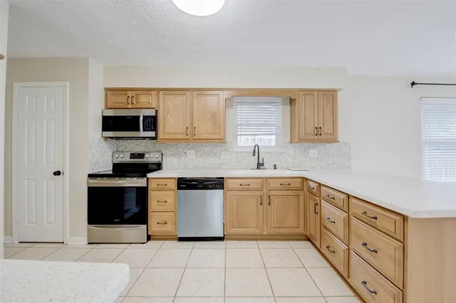 a kitchen with stainless steel appliances granite countertop a sink and a stove