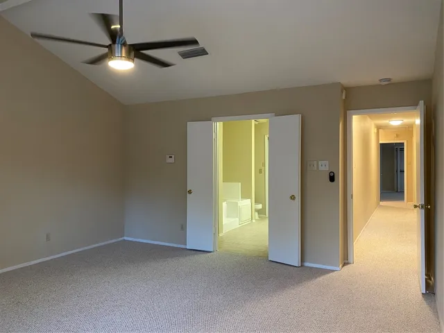 an empty room with windows and fan