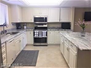 a kitchen with stainless steel appliances granite countertop a stove top oven a sink dishwasher and a refrigerator