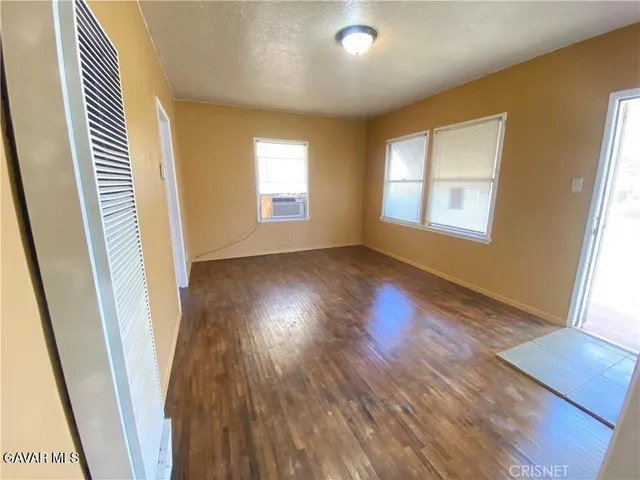 a view of a room with wooden floor and windows