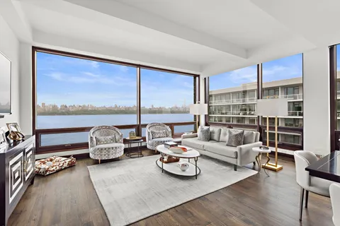 a living room with furniture and a floor to ceiling window