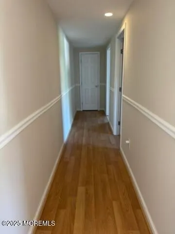 a view of a hallway with wooden floor