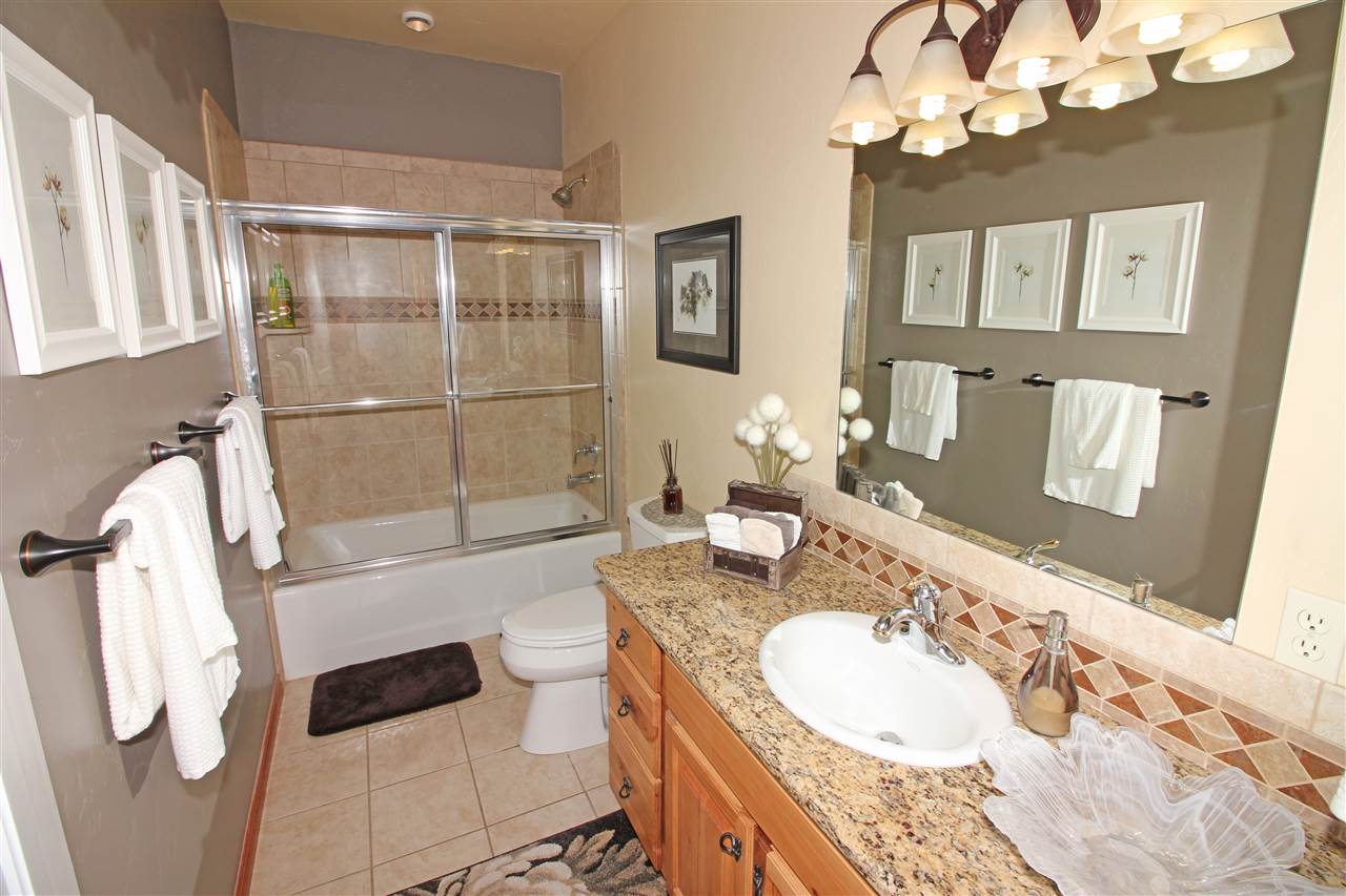 1116 22 Road Grand Junction, CO 81505 - Photo 29 of 42 a bathroom with a granite countertop double vanity sink a mirror a bathtub and shower