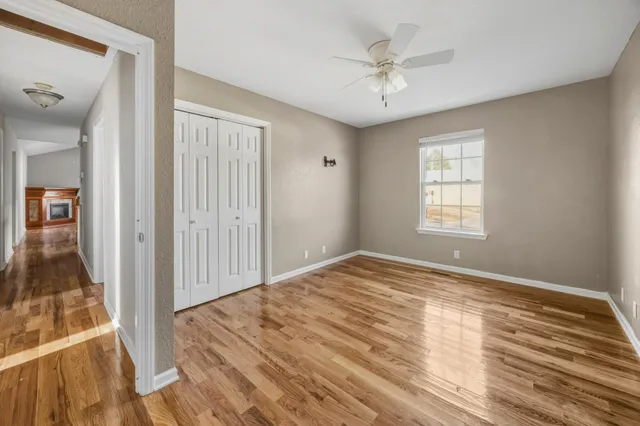 a view of empty room with window and ceiling fan
