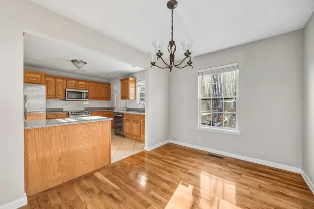 a view of a kitchen with kitchen island a counter top space a sink stainless steel appliances and cabinets