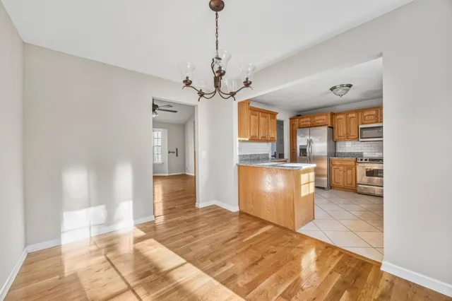a large kitchen with kitchen island a stove a sink cabinets and wooden floor