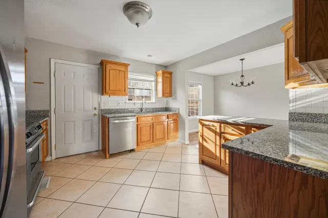 a kitchen with stainless steel appliances granite countertop a stove a sink and a refrigerator