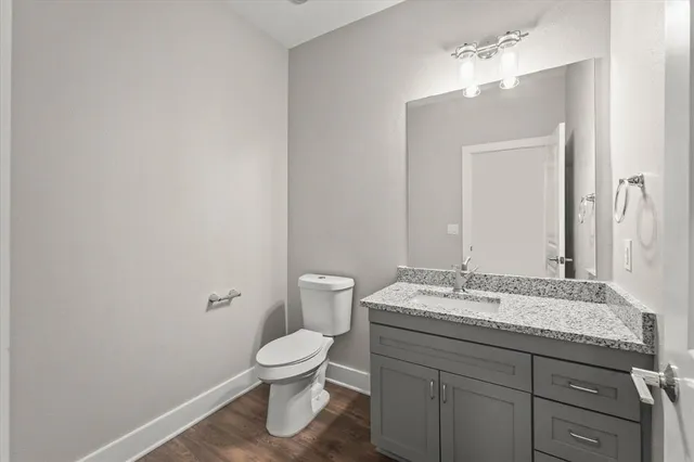 a bathroom with a granite countertop toilet sink and mirror