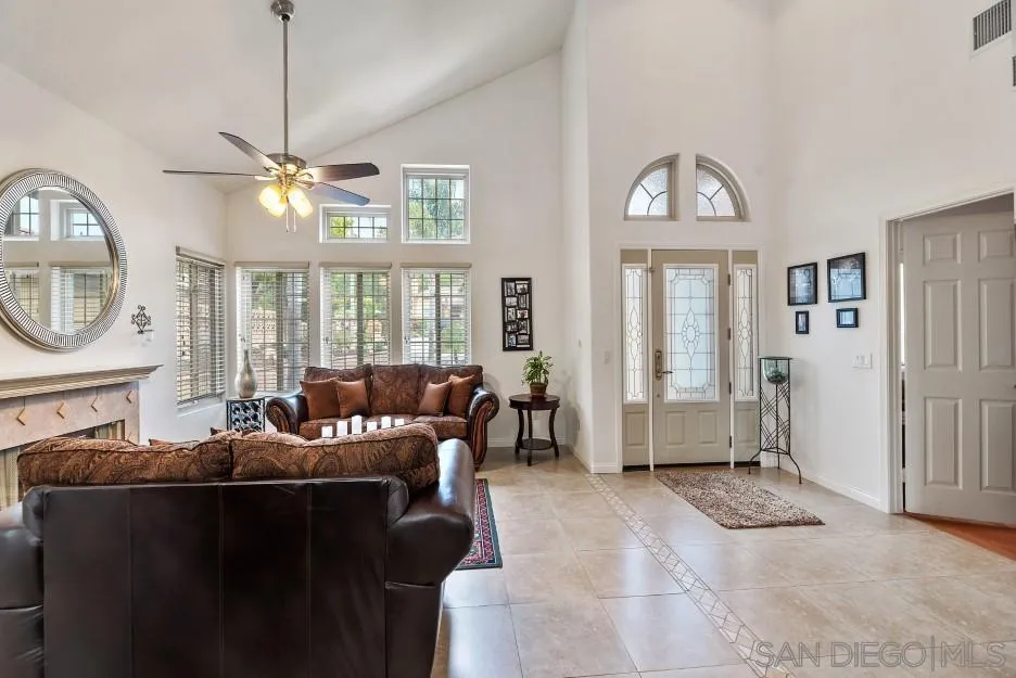 14420 Silver Heights Road Poway, CA 92064 - Photo 26 of 73 a living room with furniture a fireplace and a chandelier