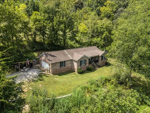 an aerial view of a house with yard and roof