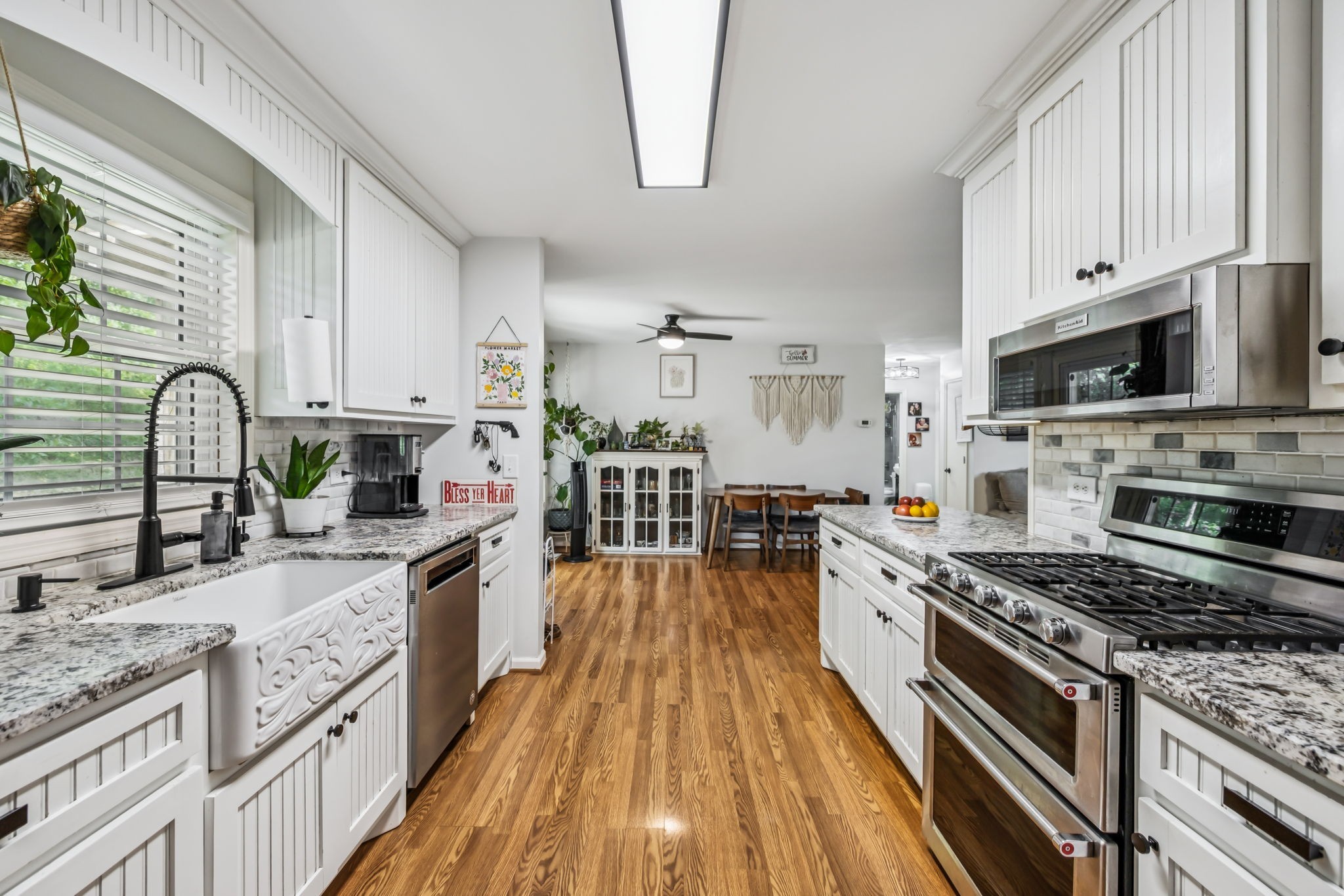 4951 Weakley Creek Road Lawrenceburg, TN 38464 - Photo 6 of 75 a kitchen with stainless steel appliances granite countertop a stove top oven a sink dishwasher and a microwave oven with white cabinets