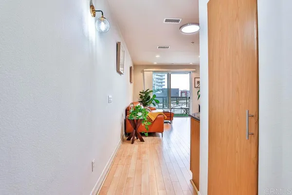 a view of a hallway with wooden floor and a living room