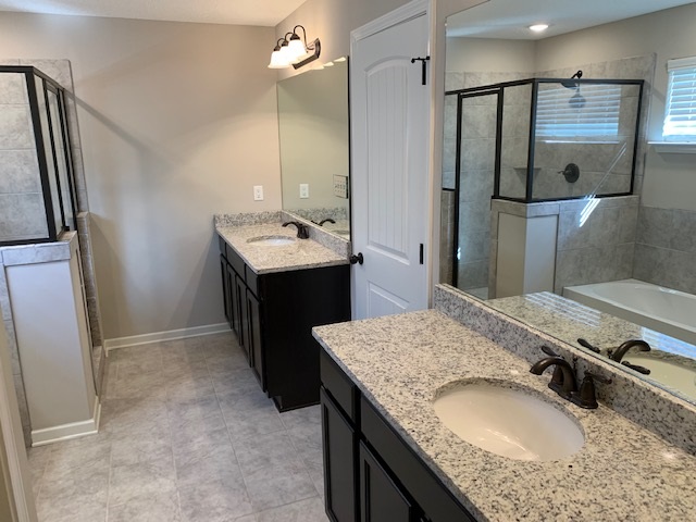 a bathroom with a granite countertop sink a mirror and shower