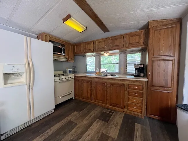 a kitchen with refrigerator cabinets and wooden floor