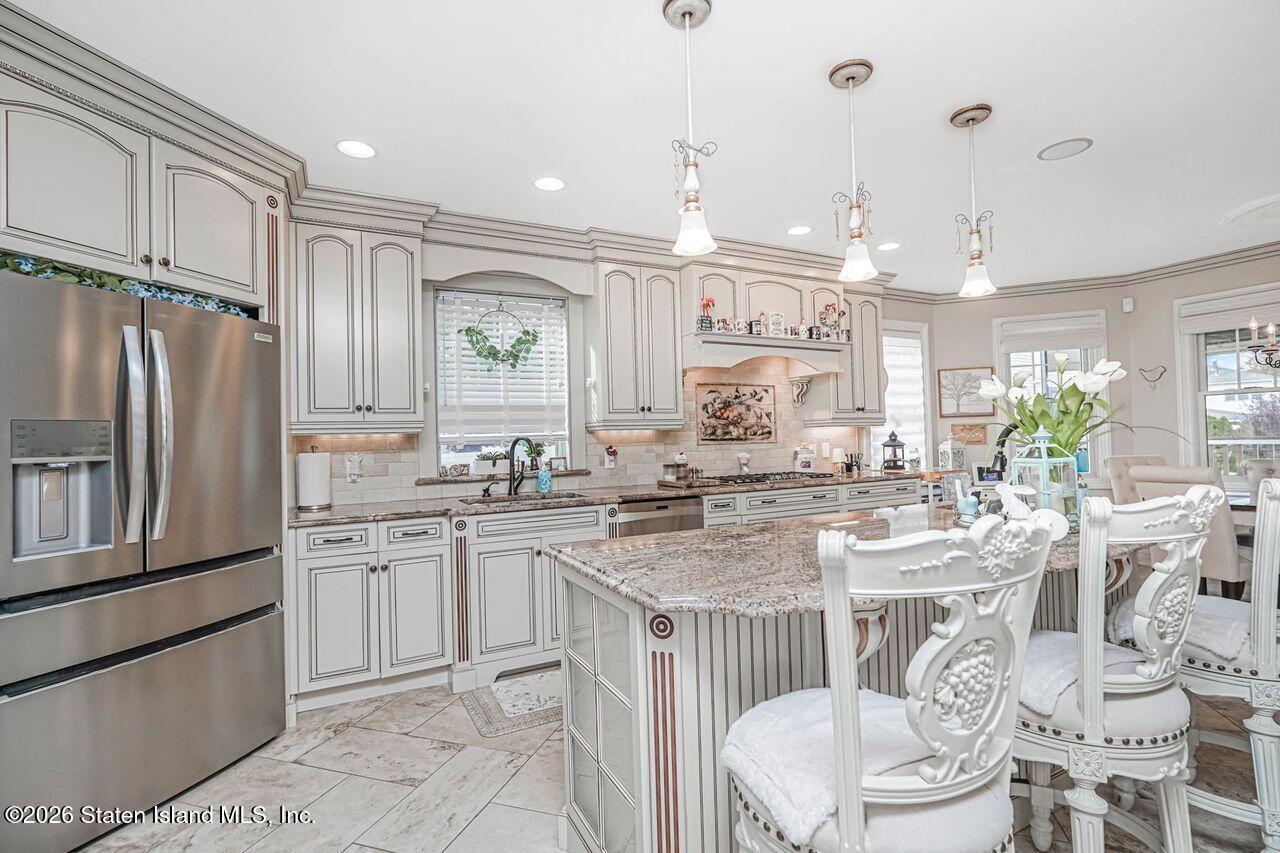 63 Finlay Avenue Staten Island, NY 10309 - Photo 14 of 44 a kitchen with stainless steel appliances granite countertop a sink a stove a dining table and chairs