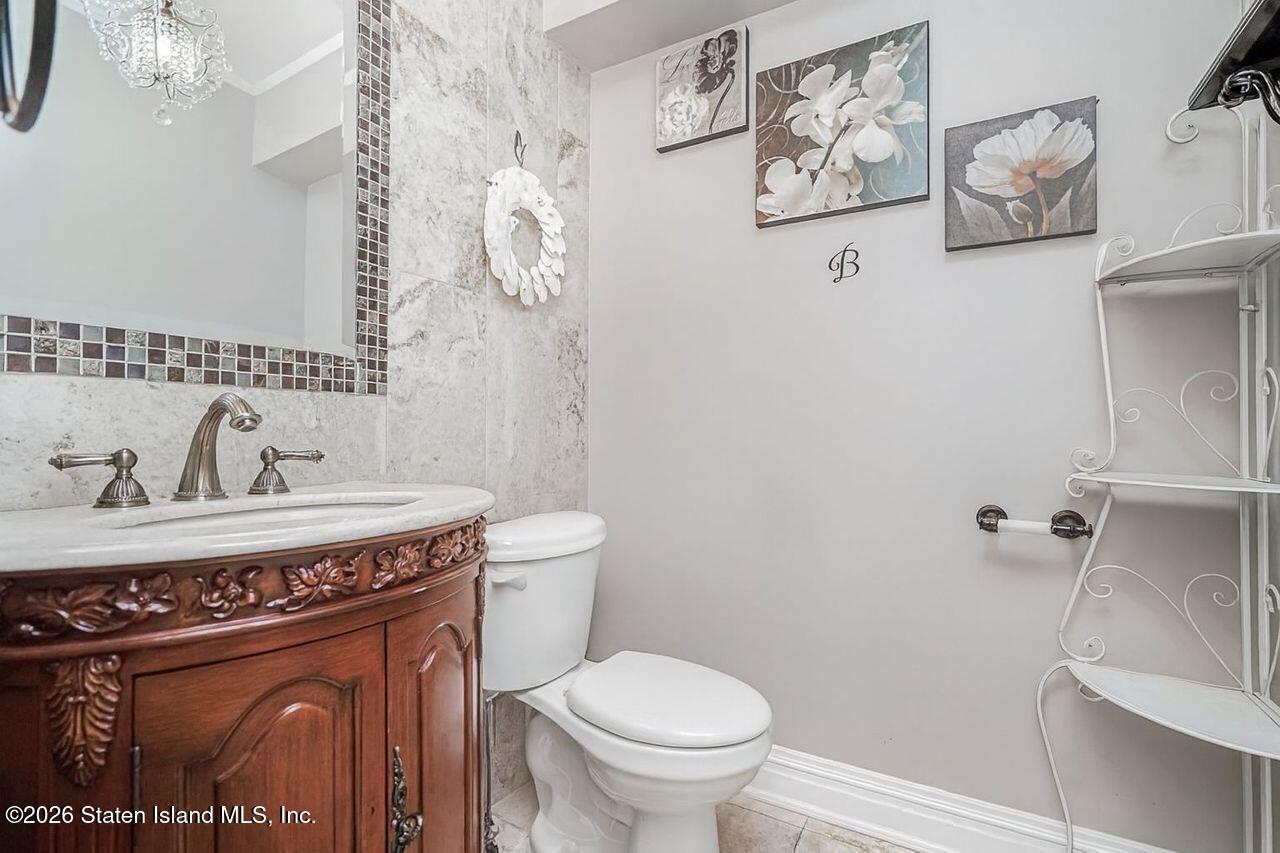63 Finlay Avenue Staten Island, NY 10309 - Photo 35 of 44 a bathroom with a toilet a sink and mirror