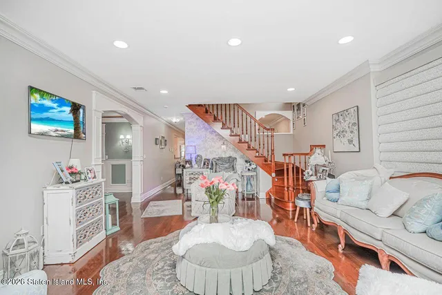 a living room with furniture floor to ceiling window and wooden floor