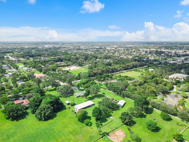 an aerial view of residential houses with outdoor space and trees