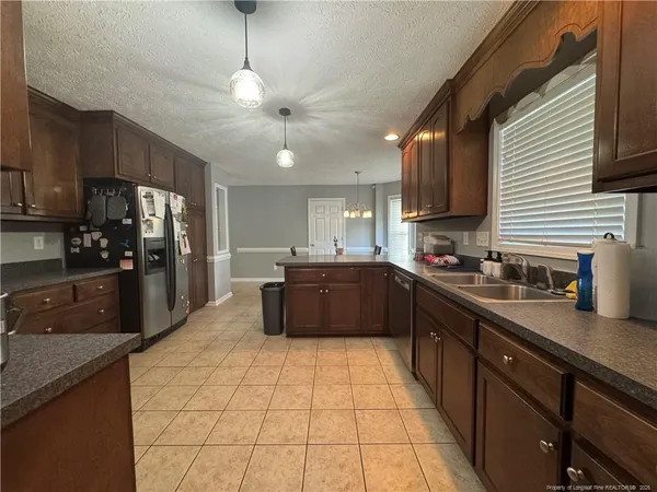 a large kitchen with stainless steel appliances granite countertop a refrigerator a sink a stove and dishwasher