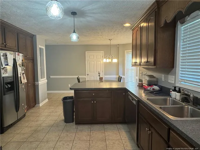 a kitchen with a sink refrigerator and cabinets