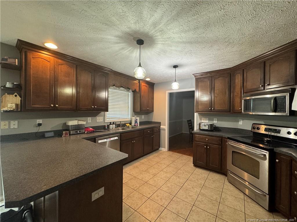 912 Lewis Street Raeford, NC 28376 - Photo 25 of 45 a kitchen with stainless steel appliances granite countertop a sink stove and refrigerator
