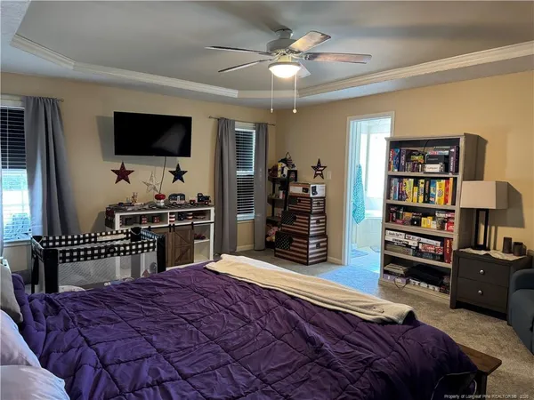 a bedroom with a bed bookshelf and a flat screen tv