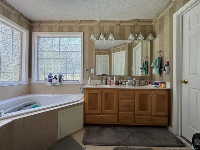 a bathroom with a tub sink and mirror