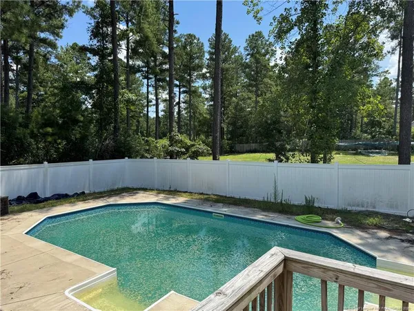 a view of a backyard with swimming pool