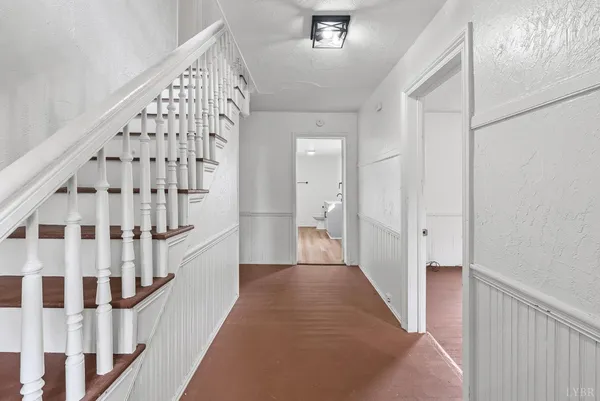 a view of a hallway with wooden floor and staircase