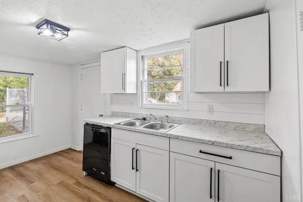 a view with cabinets a window and wooden floor