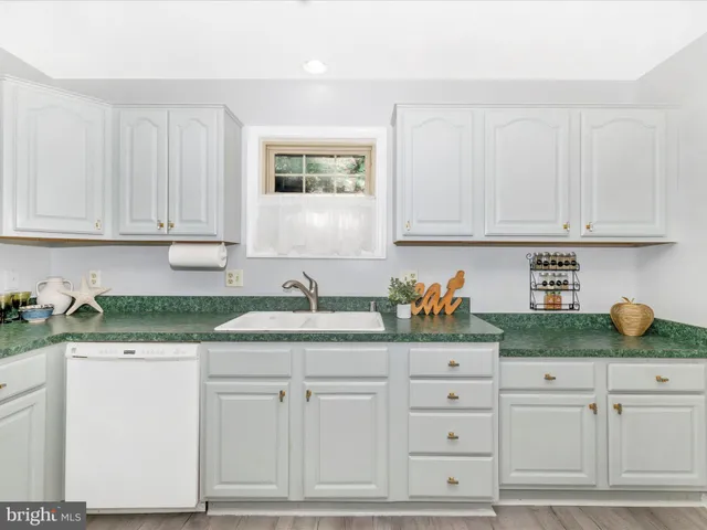 a living room with furniture a couch and a window with potted plants