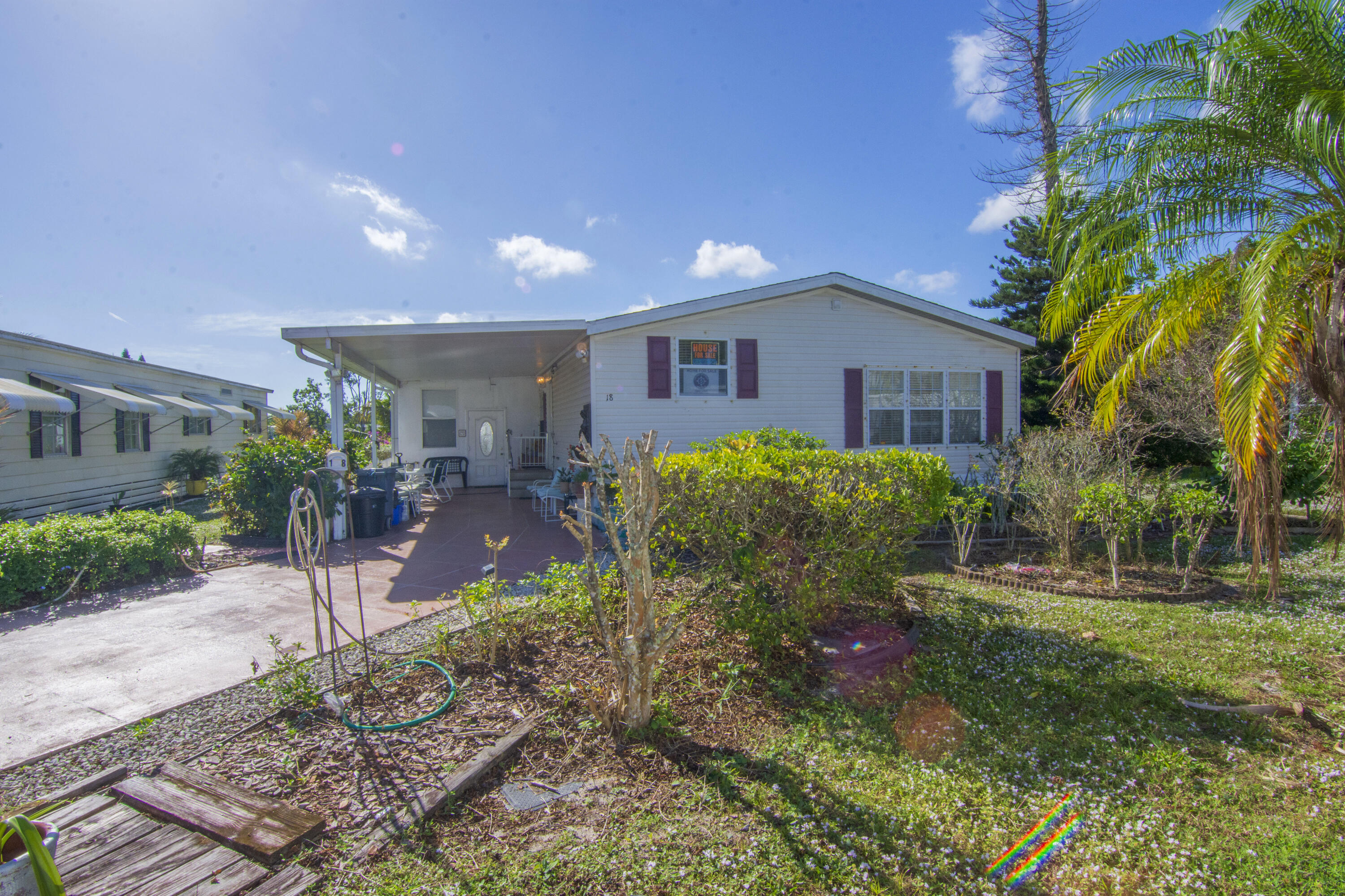 18 Nuevo Leon Road Port St. Lucie, FL 34952 - Photo 27 of 36 a view of a house with a yard and a garden