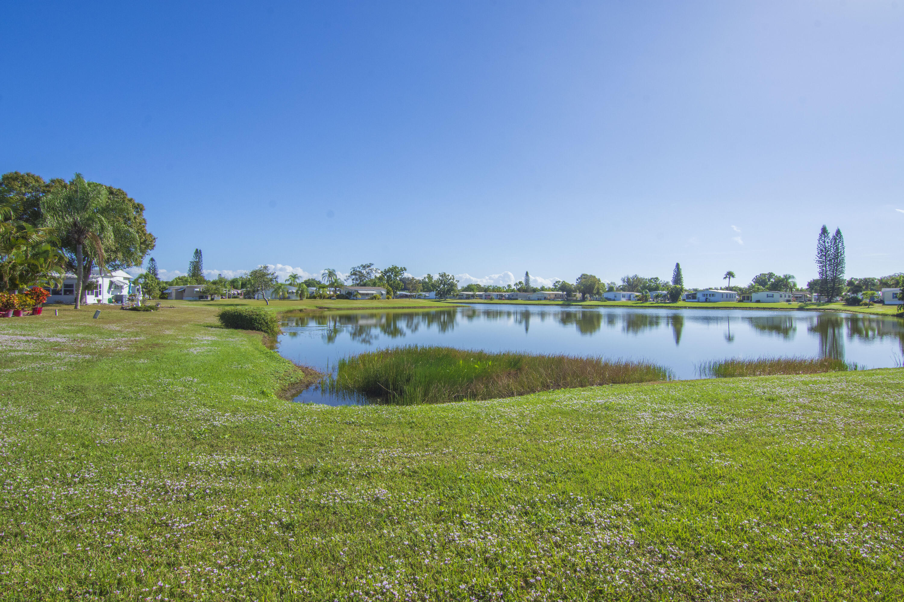 18 Nuevo Leon Road Port St. Lucie, FL 34952 - Photo 29 of 36 a view of a lake with houses in the background