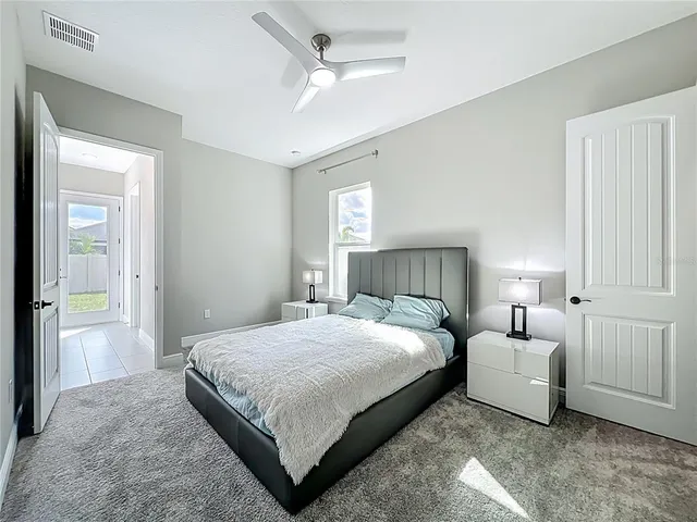 a spacious bedroom with a bed and a lamp