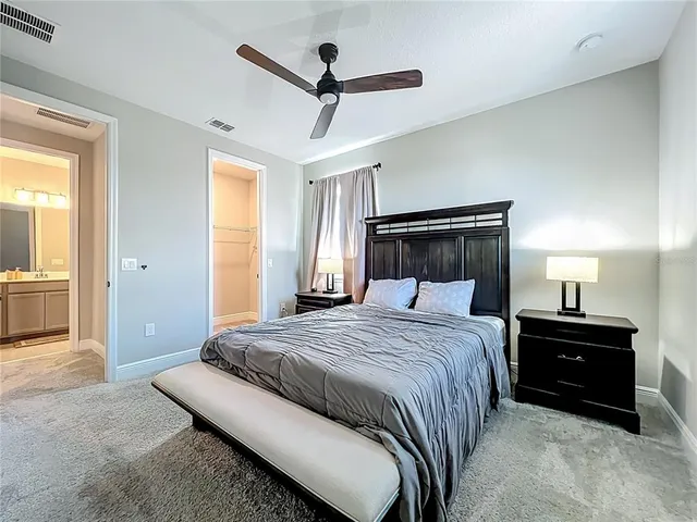 a spacious bedroom with a large bed and a chandelier