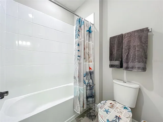 a white house that has a big yard with large trees