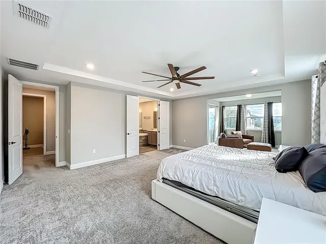 a view of a yard in front of a house with plants and large tree