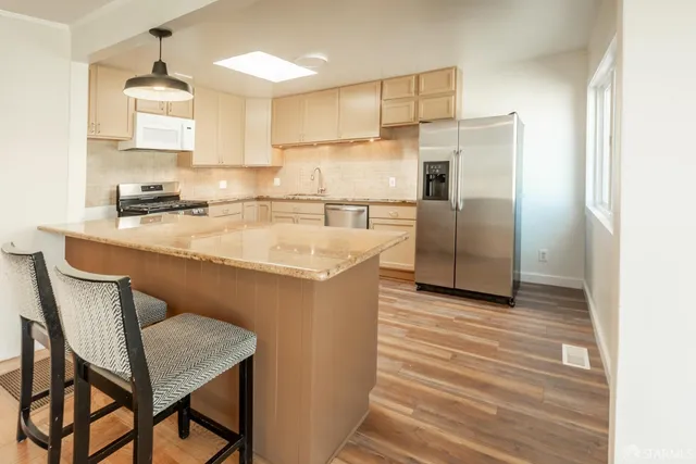 a kitchen with a table chairs refrigerator and microwave