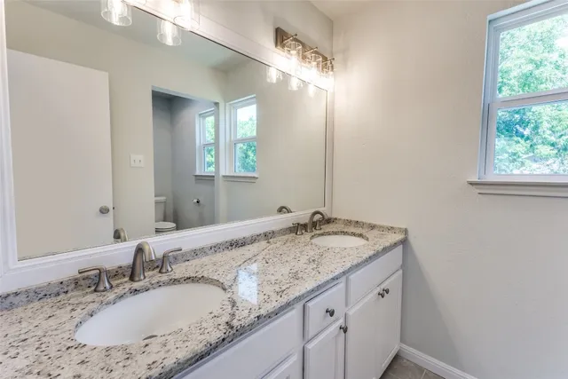 a bathroom with a granite countertop sink and a mirror
