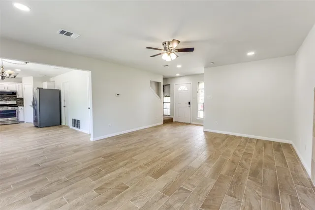 a view of an empty room with a kitchen