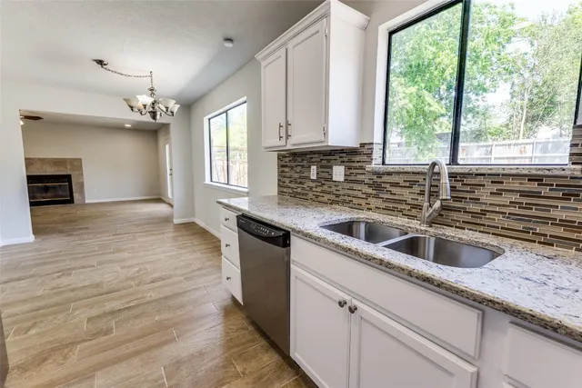 a kitchen with granite countertop a sink and a wooden floor