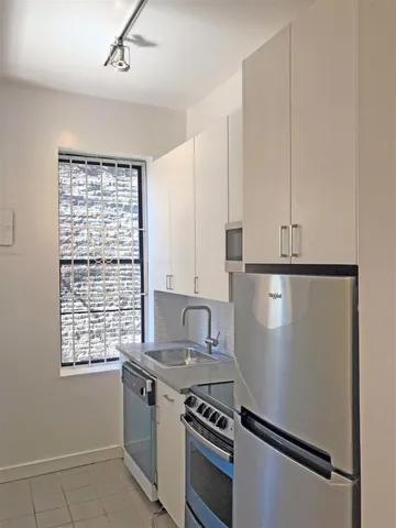 a stove top oven sitting inside of a kitchen